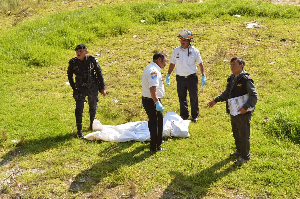 Socorristas y agentes policiales resguardan el cadáver de un joven localizado en la cabecera de Totonicapán. (Foto Prensa Libre: Édgar Domínguez)