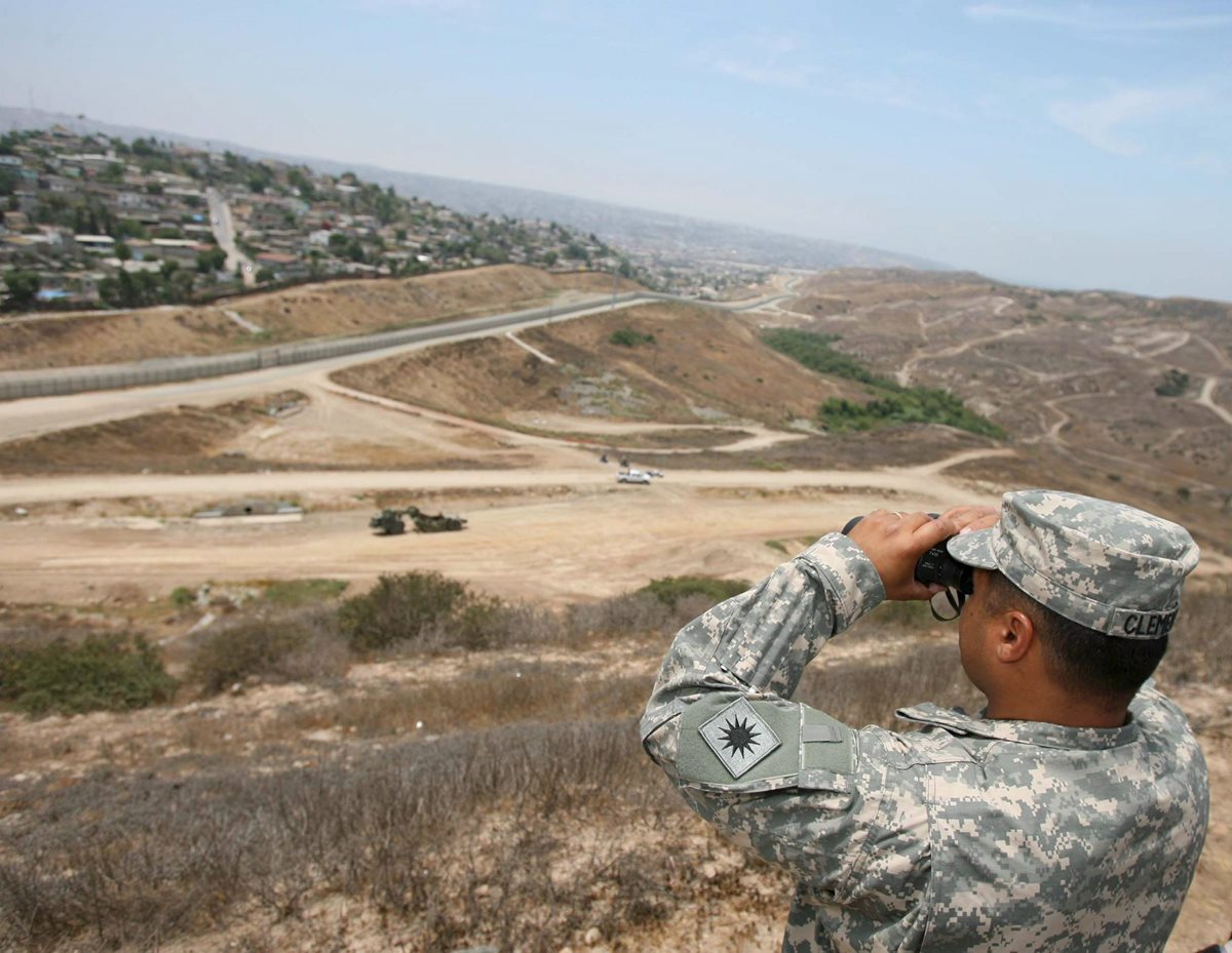 Un efectivo de la Guardia Nacional observa hacia Tijuana en México, frontera con EE. UU. cerca a Otay Mesa, California.(Foto Prensa Libre:EFE).