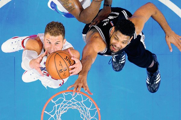 Blake Griffin, busca la anotación ante el acoso de Tim Duncan. (Foto Prensa Libre: AP)