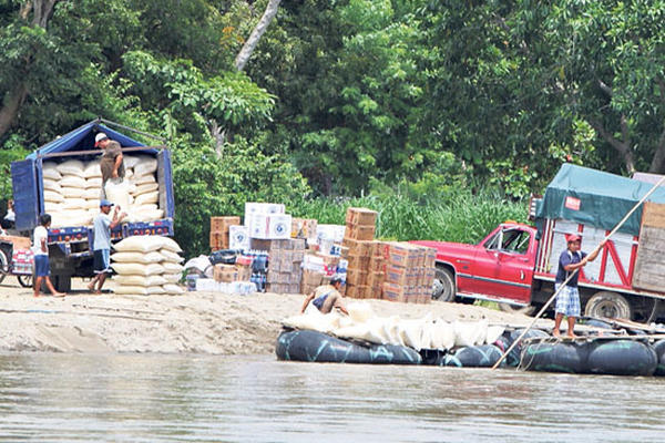 De un picop se descarga maíz que se compra en México y se traslada al país por el río Suchiate.