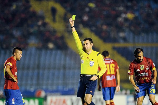 Mario Escobar le muestra una tarjeta amarilla a un jugador de Municipal, en el encuentro contra los cremas, en el clásico 287 (Foto Prensa Libre: Francisco Sánchez)