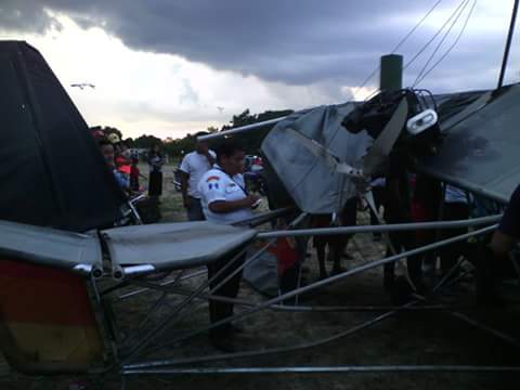 Un bombero ayuda a rescatar al turista que se accidentó en un planeador en Poptún, Petén. (Foto Prensa Libre: Walfredo Obando y Rigoberto Escobar)