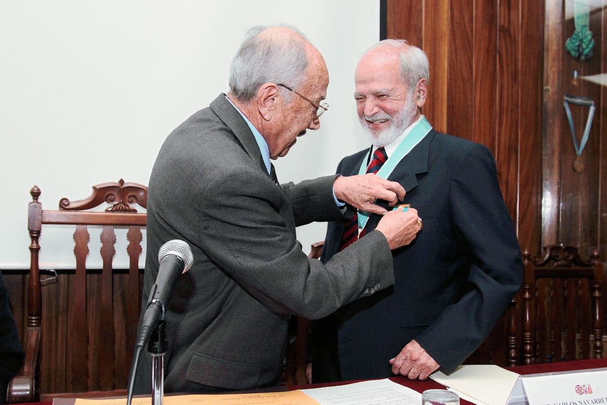 Jorge Mario García Laguardia, director de la Academia de Geografía e Historia de Guatemala, (AGHG), impone la Medalla al Mérito de esa institución, a Carlos Navarrete Cáceres. (Foto Prensa Libre: Edwin Castro)