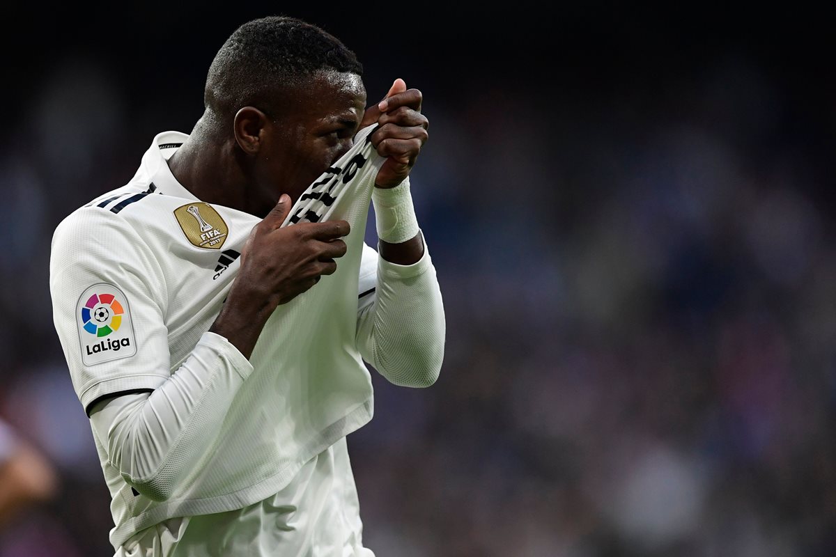 El brasileño Vinicius besa el escudo del Real Madrid después del primer gol merengue, en el Bernabéu. (Foto Prensa Libre: AFP)