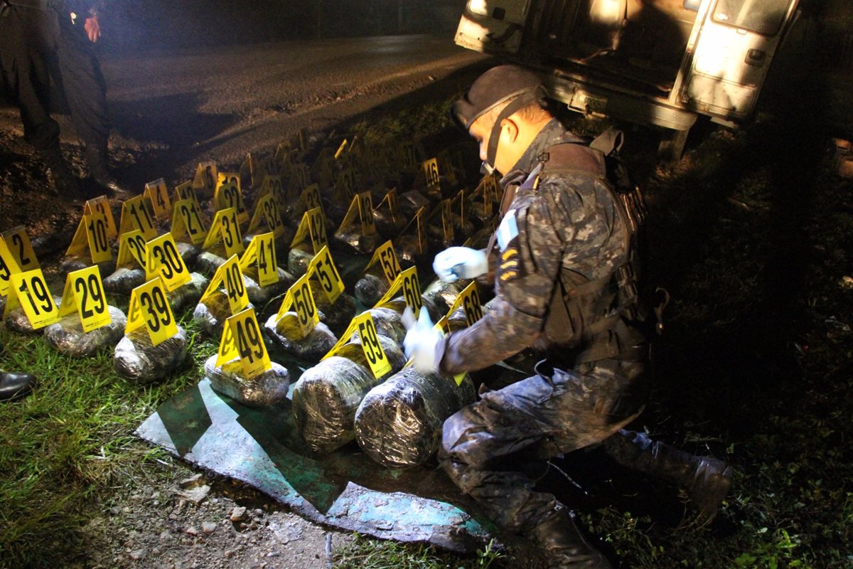Agentes antinarcóticos de la PNC contabilizan droga incautada en Dolores, Petén. (Foto Prensa Libre: PNC)