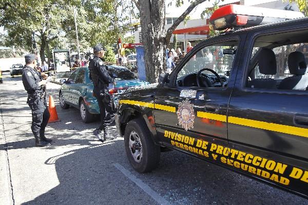 Policías vigilan vehículo de presuntos delincuentes.