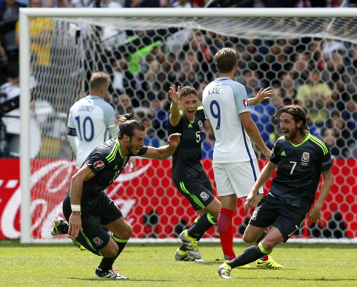 El galés Gareth Bale (izquierda) sonríe y comienza el festejo después de anotar de tiro libre contra Inglaterra. (Foto Prensa Libre: EFE)