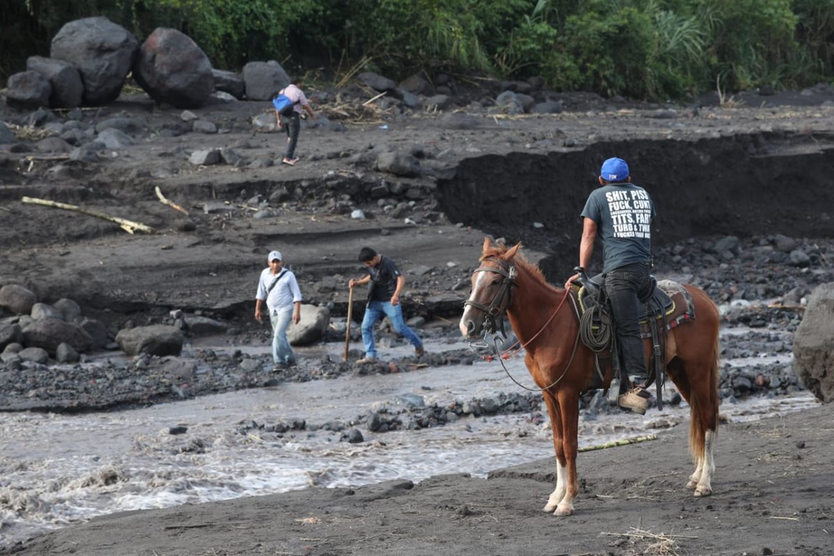 Ante la falta de camino, vecinos de seis comunidades de San Pedro Yepocapa cruzan el río Taniluya, que arrastra material volcánico. (Foto Prensa Libre: Esbin García)