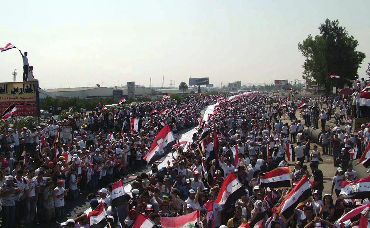 Manifestantes con una bandera nacional de 16 kilómetros en una muestra de apoyo al diálogo nacional convocado por el presidente sirio Bashar al Asad el 10 de julio de 2011 en Latakia, Siria. (Foto: EFE)