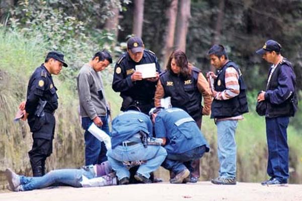 El cuerpo de una mujer, muerta ayer en Quetzaltenango, es revisado por peritos del Ministerio Público. La víctima tenía un balazo en la cabeza.