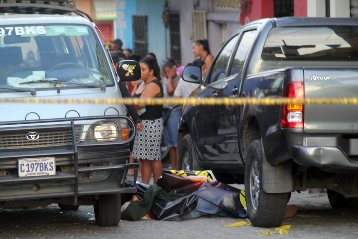 El cadáver del piloto quedó entre el microbús de pasajeros y otro vehículo. (Foto Prensa Libre: Hugo Oliva)