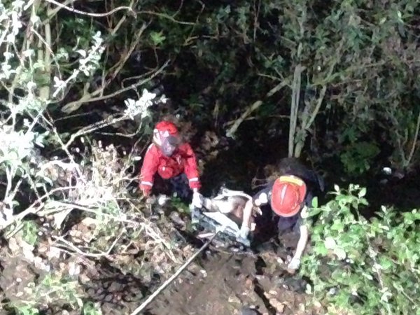 Socorristas extraen el cadáver de la víctima de un barranco en la madrugada de este jueves. (Foto Prensa Libre: Cortesía CBM)
