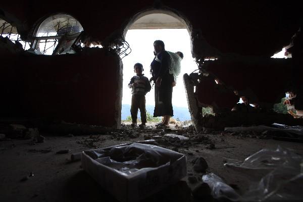 Una mujer y su hijo observan los daños  que sufrió la casa de su familia y que quedó inhabitable, en Sibinal, San Marcos.