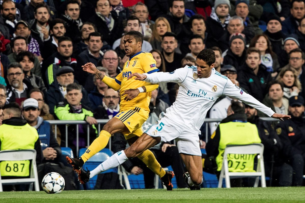 Varane pelea la pelota con Douglas Costa.