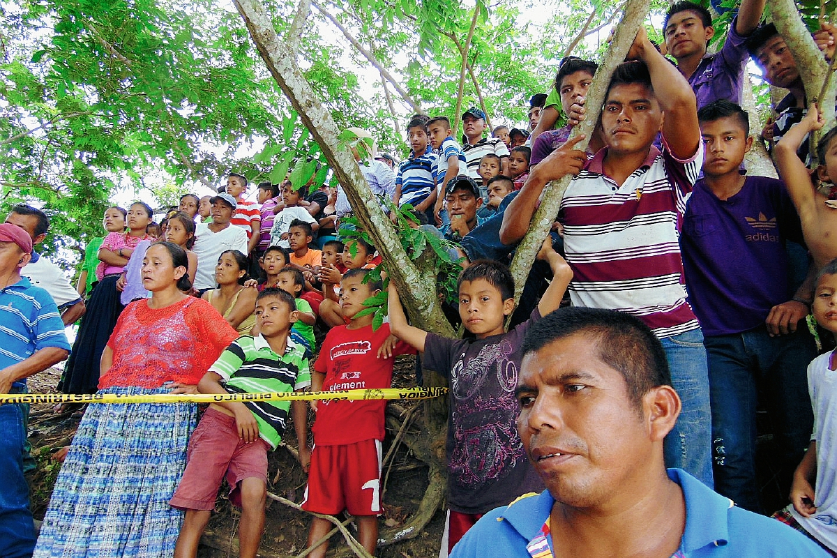 Curiosos observan el lugar donde fueron lanzados  los cadáveres de dos hombres en Sayaxché, Petén. (Foto Prensa Libre: Rigoberto Escobar)