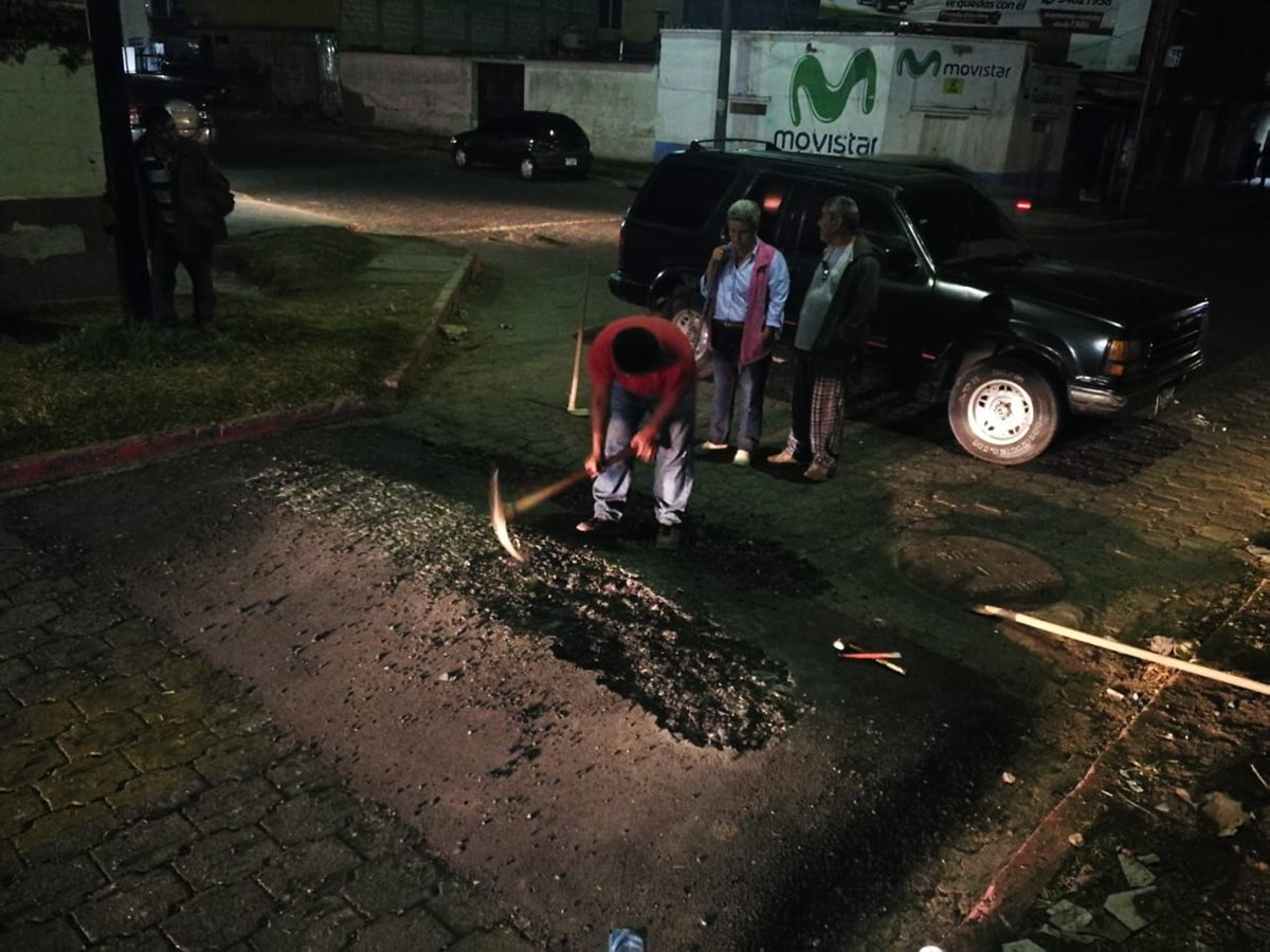 Con una piocha una persona reduce la altura de uno de los túmulos en la 30 avenida de la zona 3, residencial Delco. (Foto Prensa Libre: Mynor Toc)