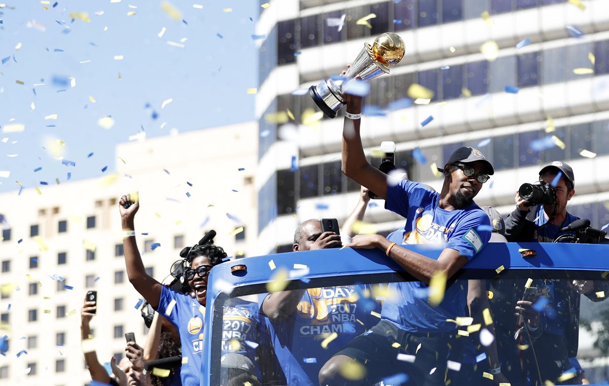 Los jugadores de los Warriors celebran con los miles de seguidores el título de la NBA. (Foto Prensa Libre: AFP)