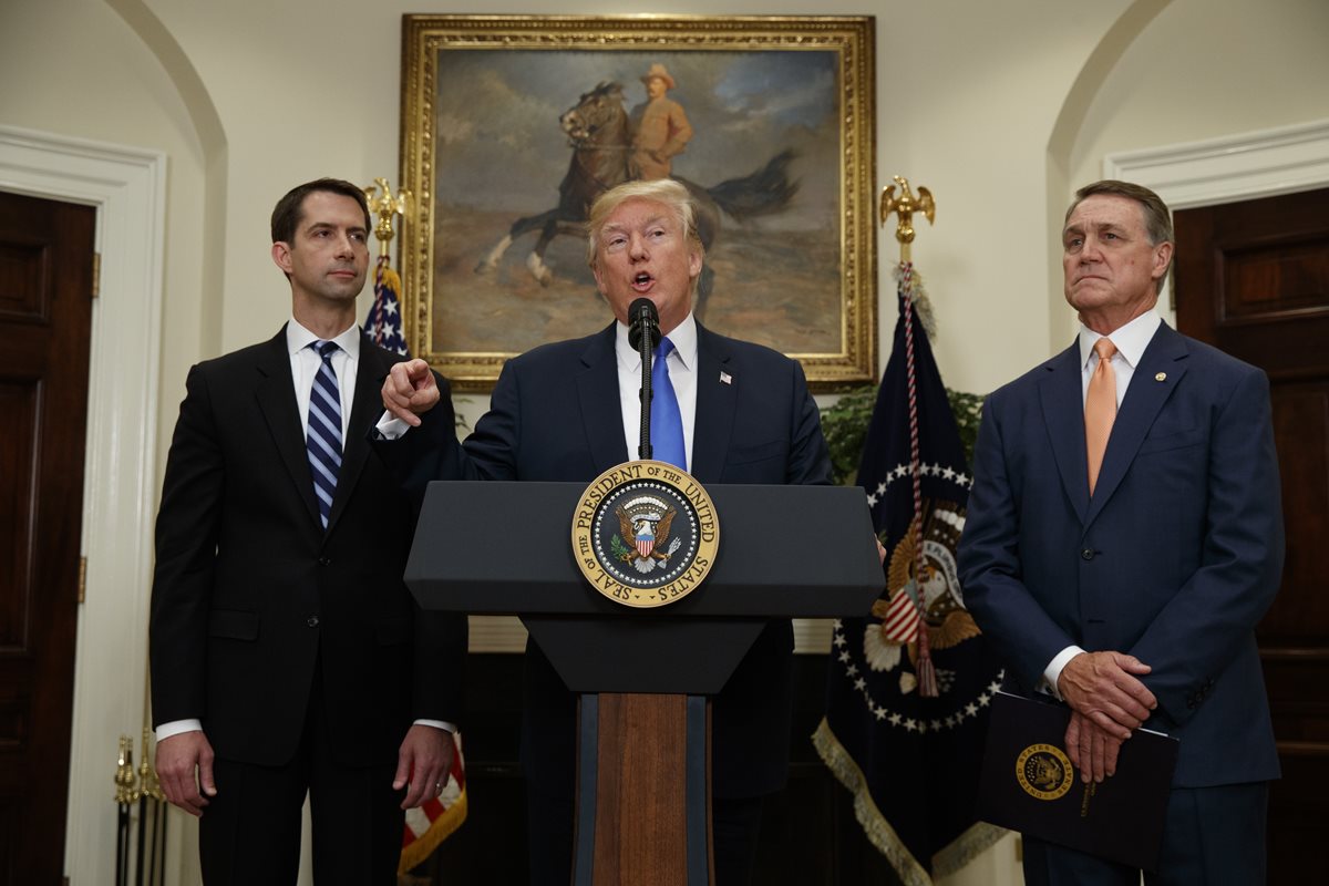 Donald Trump, junto a los legisladores que proponen reducir en 50% la migración legal. (Foto Prensa Libre: AP)