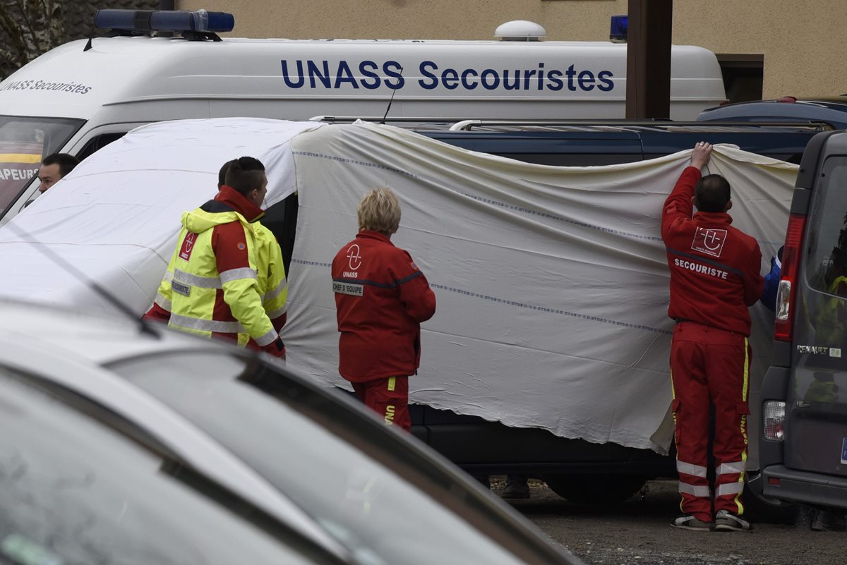 Forenses cubren el microbús involucrado en el accidente. (Foto Prensa Libre: AFP).