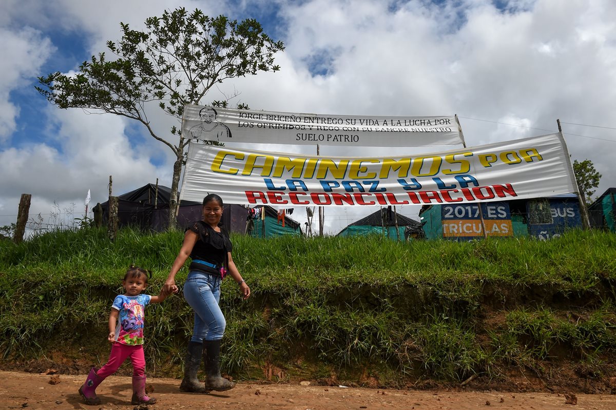 Una excombatiente camina con su hija por la zona de transición en Mesetas, Colombia. (Foto Prensa Libre: AFP)