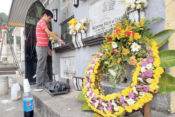 <p style="text-align: left;">Un niño ayuda a limpiar la tumba de un familiar en el cementerio de San Juan Sacatepéquez.</p>
