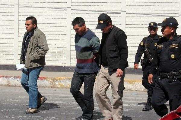 Pedro López  es conducido  por agentes policiales.