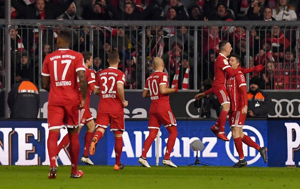 Robert Lewandowski es felicitado por sus compañeros luego de anotar el primer gol. (Foto Prensa Libre: EFE)