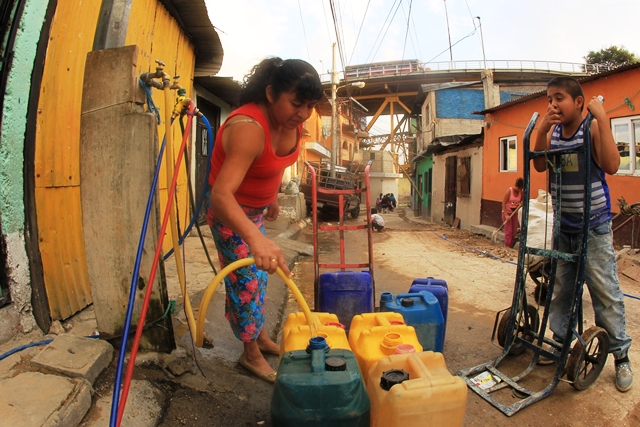 La única calle ancha del barrio se pinta de colores cuando los vecinos del sector 4 desfilan en las calles con sus recipientes para abastecerse de agua, ya que tenerla en casa es una labor titánica en el lugar, que solo cuenta con dos chorros públicos. (Foto Prensa Libre: Esbin García)