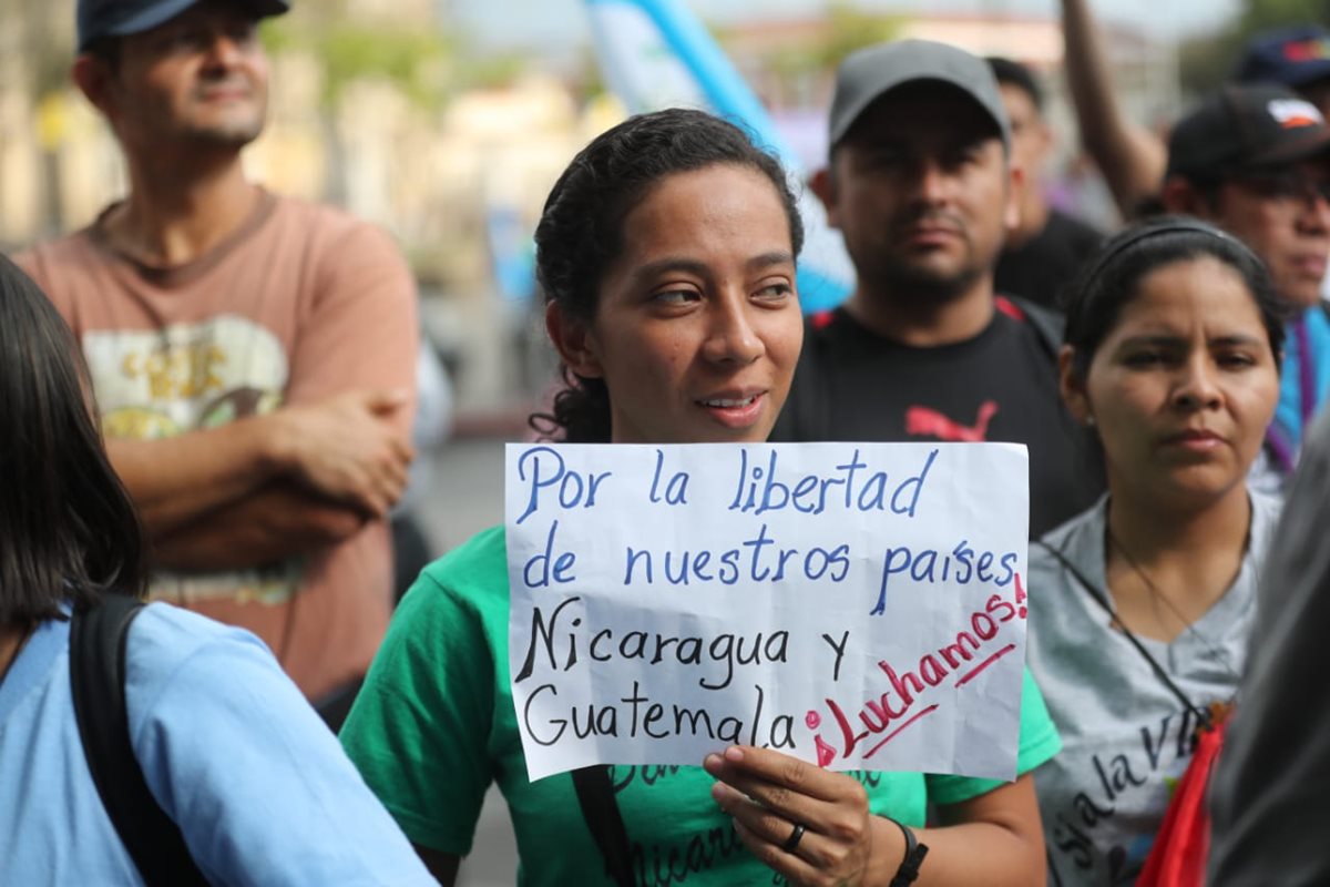 Algunos manifestantes portan pancartas frente al Palacio Nacional