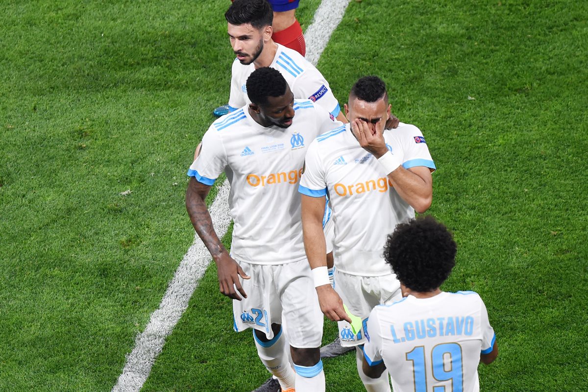 Payet sale de la cancha acompañado de su compañero Andre-Frank Zambo Anguissa. (Foto Prensa Libre: AFP)