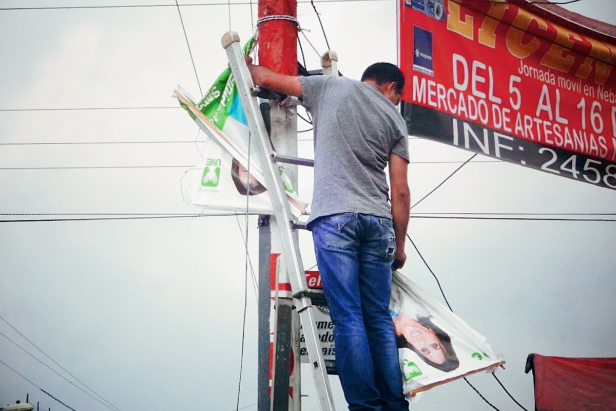 Un vecino  de Chicamán, Quiché, retira propaganda de partidos políticos de un poste. (Foto Prensa Libre: Óscar Figueroa)