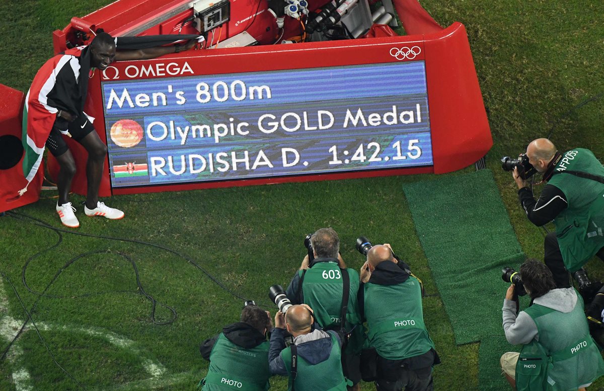 David Rudisha posa junto a la pantalla que anuncia su oro olímpico. (Foto Prensa Libre: AFP)