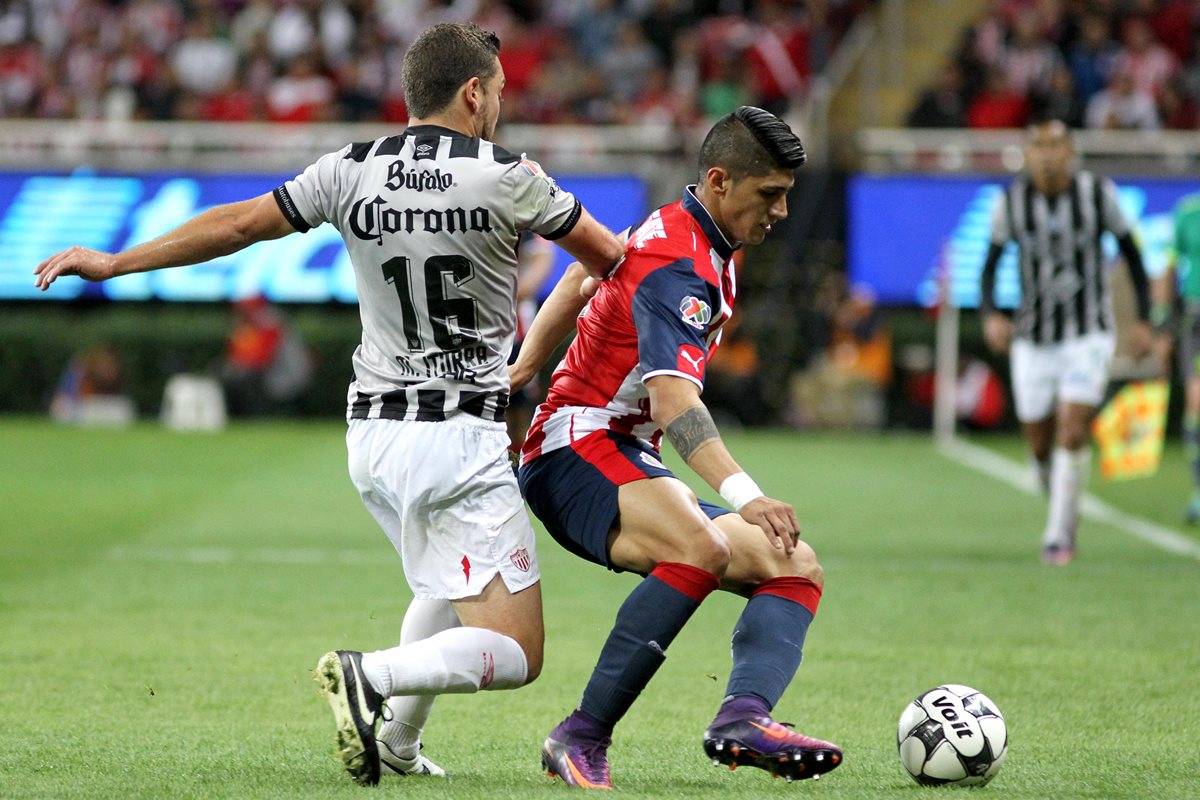 Alan Pulido de Chivas del Guadalajara disputa el balón contra Manuel Iturra de Necaxa. (Foto Prensa Libre: EFE)