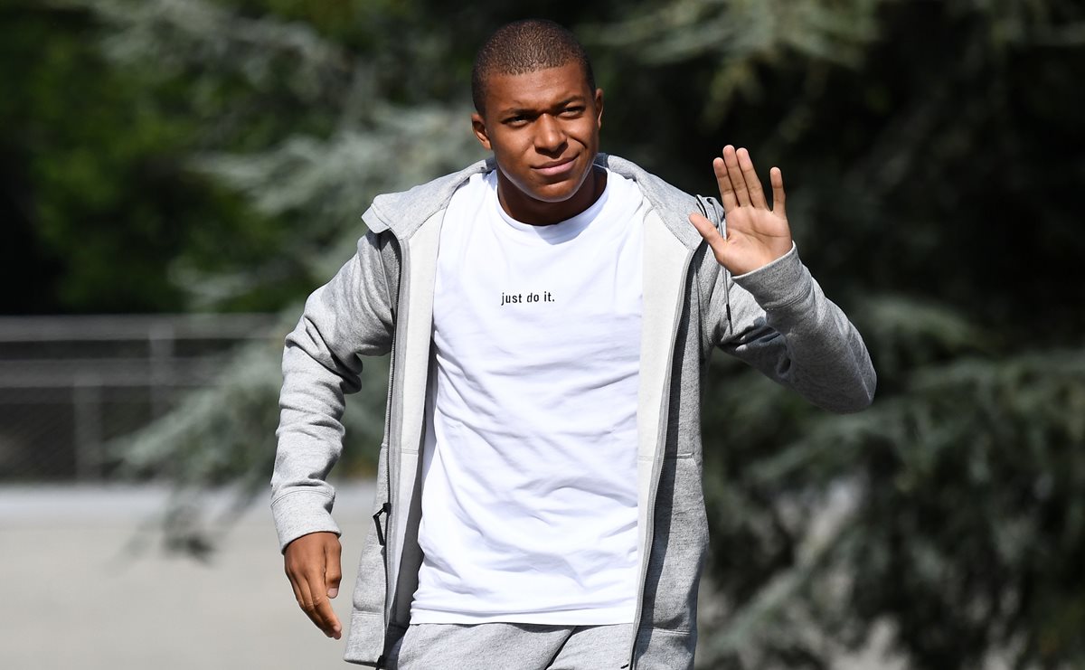 Kylian Mbappé saluda a los aficionados y medios a su llegada a la concentración de la selección francesa. (Foto Prensa Libre: AFP)