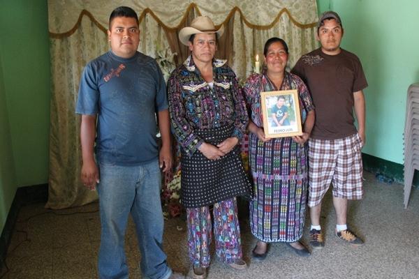 María Chipín Coroxón sostiene la fotografía de su hijo Luis, quien fue muerto por secuestradores. La acompañan Edy Rigoberto (hermano de la víctima), Pedro  Yaxón (padre) y José Francisco (hermano). (Foto Prensa Libre: Édgar Sáenz)