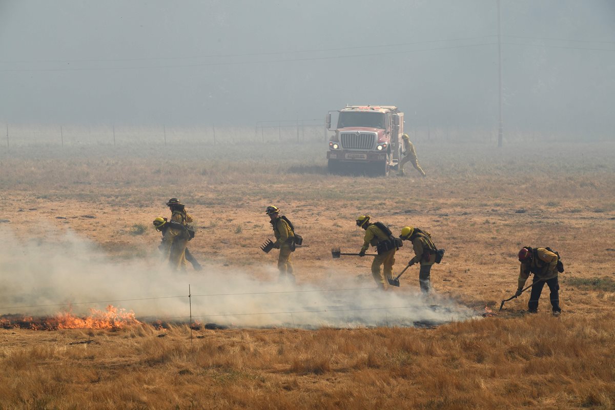 Los bomberos tratan de contener las llamas del incendio en la ciudad de Lakeport, California. (AFP)