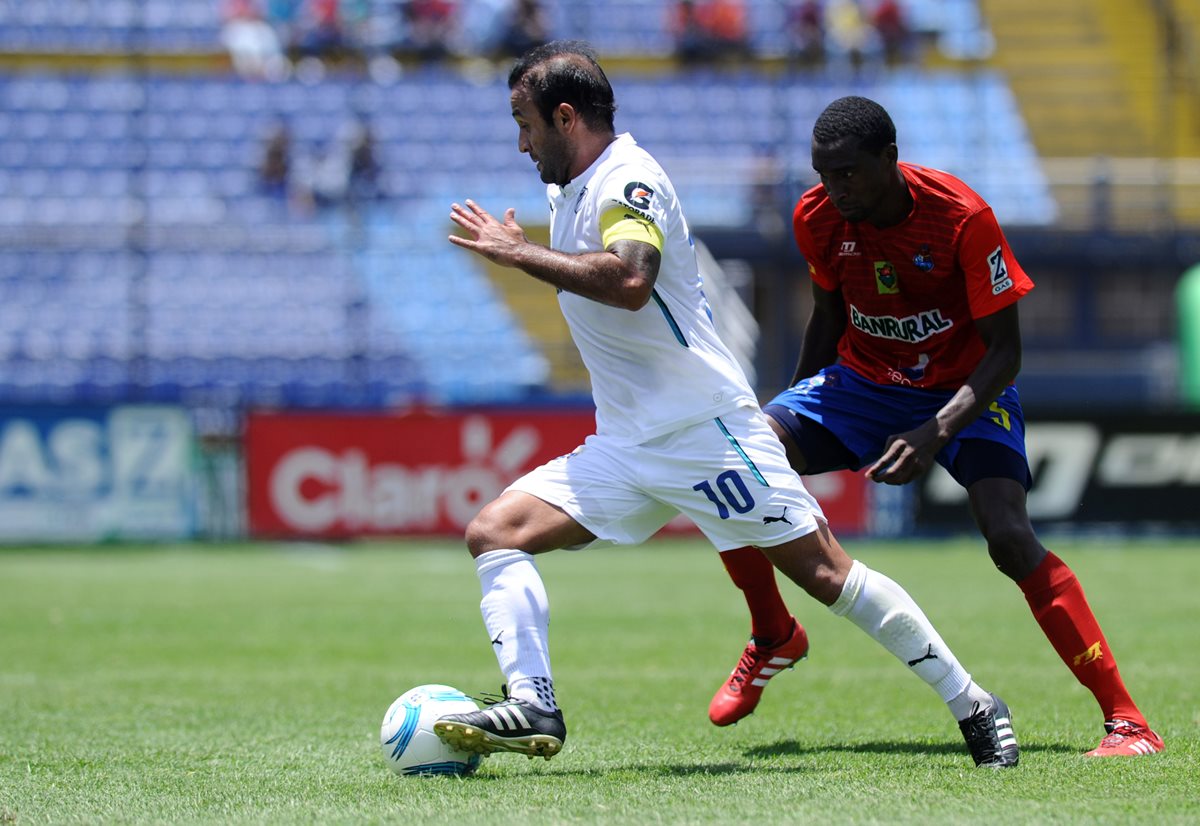 José Contreras conduce la pelota frente al defensa rojo Denniss López en una acción del clásico 294 del fin de semana. (Foto Prensa Libre: Francisco Sánchez)