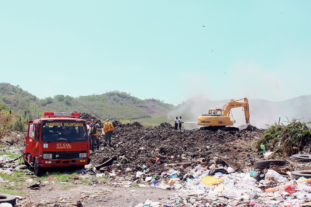 Bomberos Voluntarios  de San Benito apoyan en sofocar un incendio en el basurero municipal. (Foto Prensa Libre: Rigoberto Escobar)