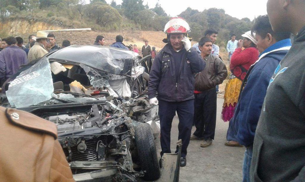 Vecinos observan el taxi en el que murieron dos personas al chocar contra tráiler, en el cruce a Concepción Tutuapa y Sipacapa, San Marcos. (Foto Prensa Libre: Whitmer Barrera)