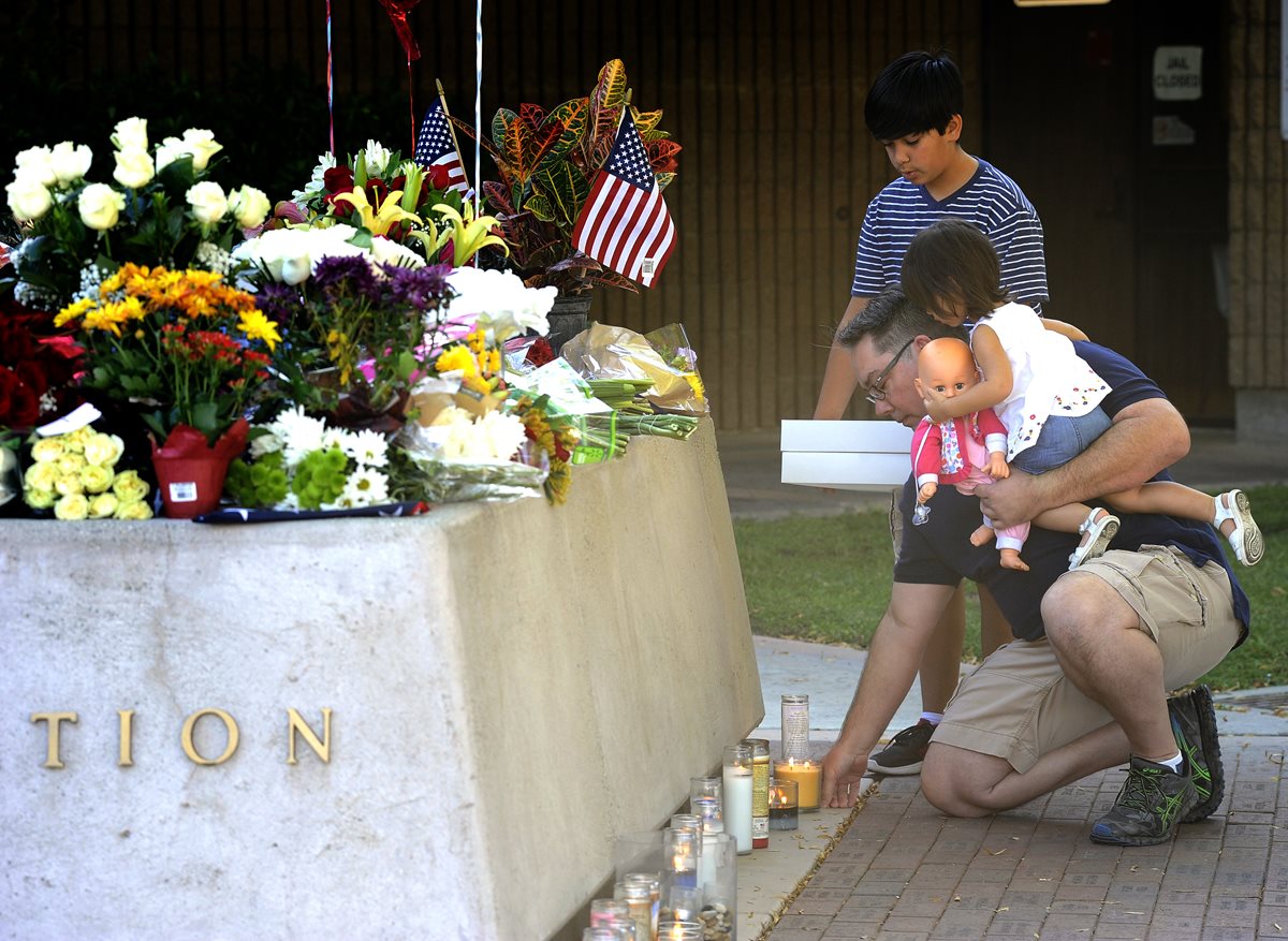 Familiares, colegas y amigos rinden tributo a los dos policías asesinados. (Foto Prensa Libre: AP).