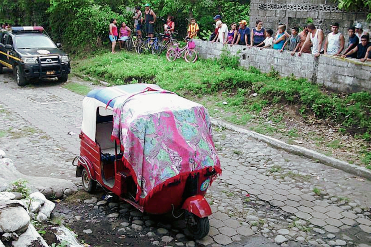 El mototoxi que conducía un piloto que fuer muerto a balazos, quedó acordonado por agentes de la PNC, minutos después de que pobladores lincharan a una mujer señalada del crimen, en Río Bravo, Suchitepéquez. (Foto Prensa Libre: Omar Méndez)