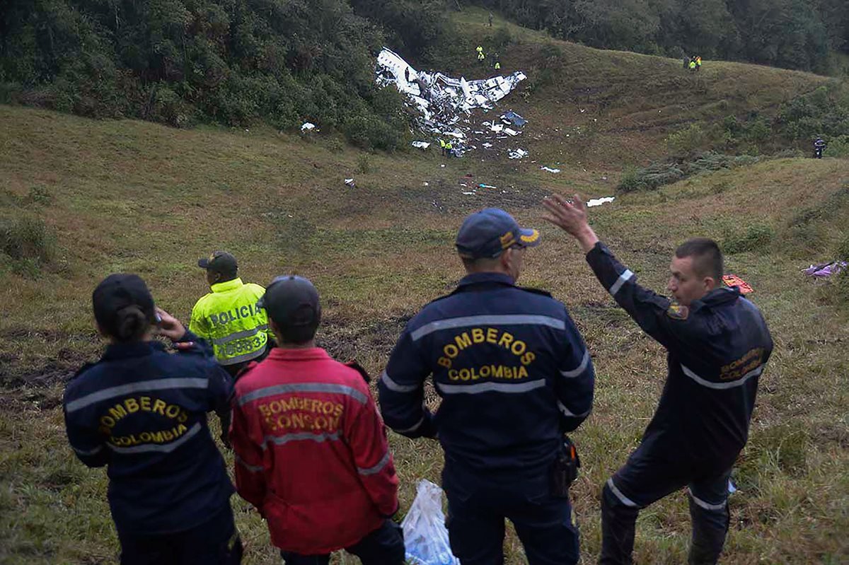 Bomberos colombianos observar el área donde impactó la aeronave que trasladaba al equipo brasileño. (Foto Prensa Libre: AFP)