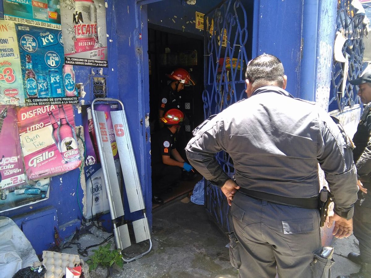 Un agente de la PNC observa como los socorristas cubren el cadáver de la víctima, en la 16 avenida y 41 calle de la zona 8. (Foto Prensa Libre: HemerotecaPL)