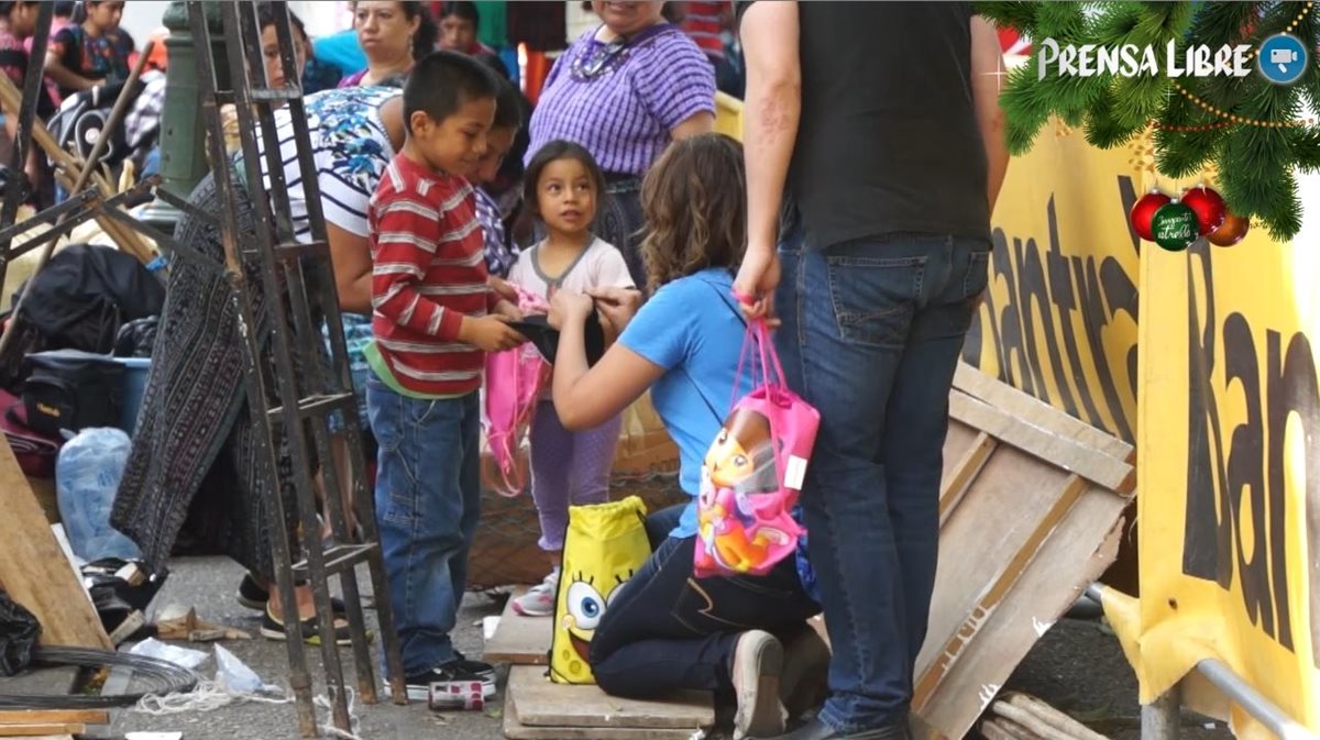 Niños, primero con incredulidad, reciben las sorpresas. Luego sonríen y agradecen. (Foto Prensa Libre: Astrid Blank)