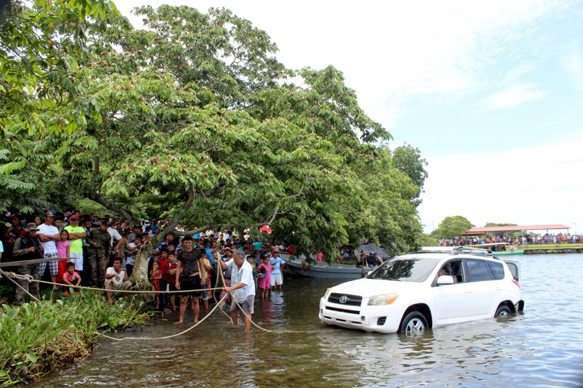 Personas observaron la extracción del vehículo que cayó al Lago de Izabal, donde una mujer falleció por causas que se investigan. (Foto Prensa Libre: Dony Stewart)