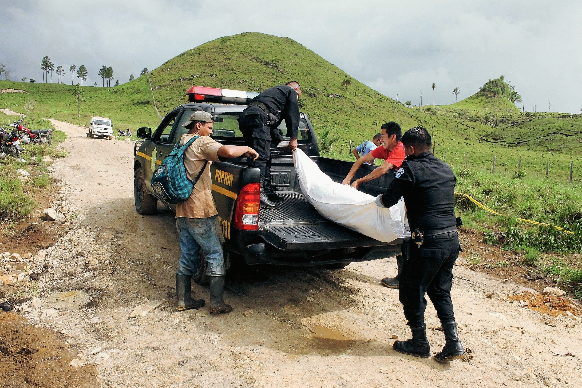 Agentes de  la PNC trasladan el cadáver de Florindo Rudy Pop Chocoj,  de 25 años, quien murió a balazos en Poptún, Petén. (Foto Prensa Libre: Walfredo Obando)