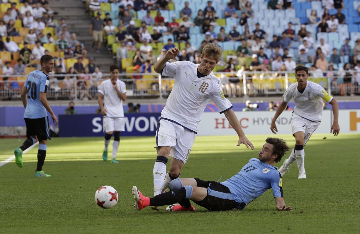 El italiano Luca Vido trata de quedarse con el balón tras la barrida del uruguayo Matias Vina. (Foto Prensa Libre: AP)