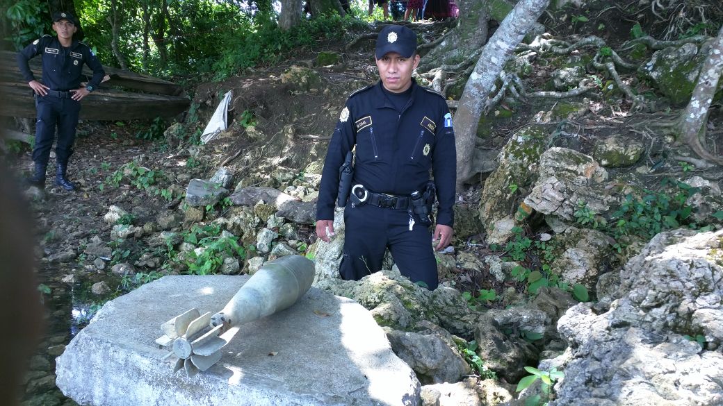 Agente de la PNC observa explosivo localizado en Sayaxché. (Foto Prensa Libre: Rigoberto Escobar).