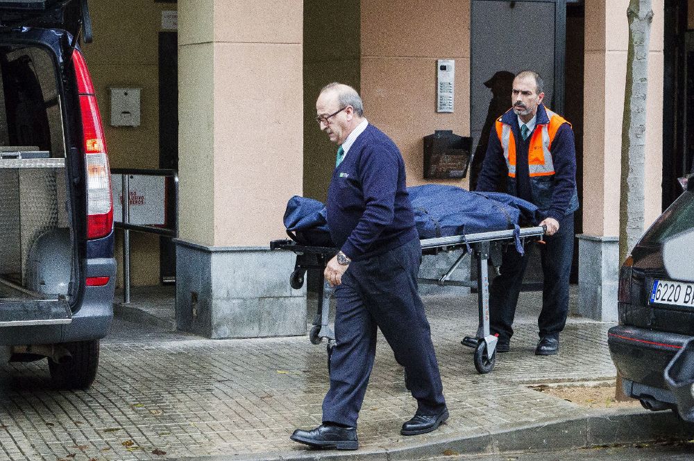 Los servicios funerarios trasladan los restos de la inmigrante africana fallecida. (EFE).