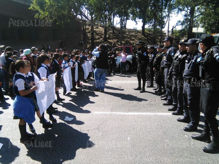 La falta de cinco maestros en la Escuela El Amparo I provocó que los alumnos y sus padres salieran a bloquear el paso el Anillo Periférico. (Foto Prensa Libre: E. Paredes)